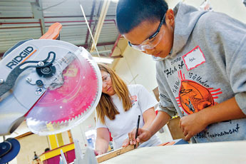 Asa Holyan, right, gets some help from Monica Green during a woodworking seminar at Tohatchi High School Tuesday. Green and her church group travelled to Tohatchi from Tennessee to help local youth. &copy; 2011 Gallup Independent / Cable Hoover 
